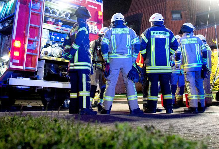Feuerwehr in Niedersachsen: Jede dritte Einsatzkraft berichtet von Gewalt Einsatzkräfte der Feuerwehr stehen vor einem Mehrfamilienhaus,