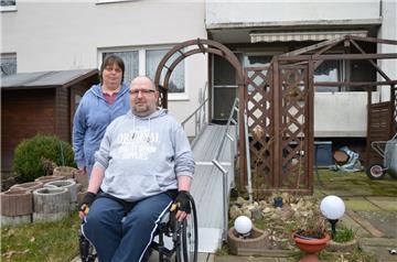 Ohne seine Frau Helga könnte Jens Stockinger gar nicht mehr die Wohnung verlassen. Schließlich wohnt das Paar im Hochparterre – Treppen sind ein unüberwindbares Hindernis auf dem Weg zur Haustür. Doch über eine Rampe, die vom Balkon in den Garten führt, kann Stockinger ins Freie gelangen.