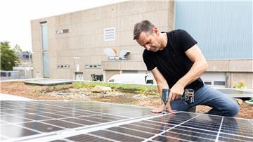 Olaf Lies, damals noch als Wirtschaftsminister, montiert ein Solarmodul auf ein Dach. (Archivbild)