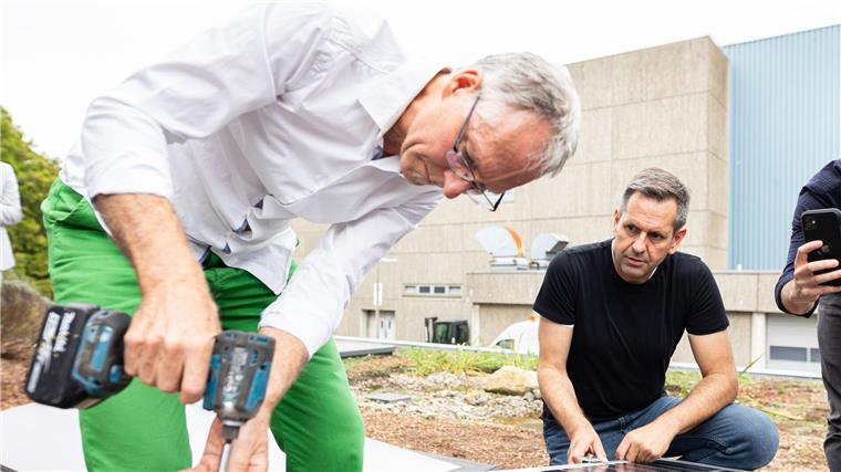 Lies: Brauchen Handwerker im Kampf gegen Klimafolgen Olaf Lies (SPD, r), Wirtschaftsminister von Niedersachsen, montiert ein Solar Modul.