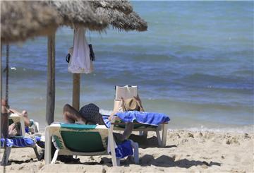  Eine Person liest am Strand Arenal. 