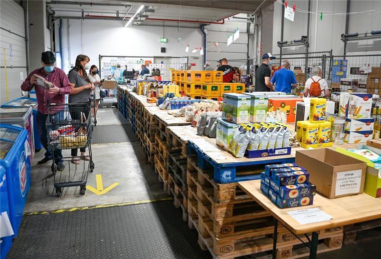Schiffdorf: Odin plant Ladengeschäft für Werksverkauf Kartons mit Lebensmitteln stehen auf Holzpaletten. Menschen mit Corona-Maske und Einkaufswagen stehen daneben.