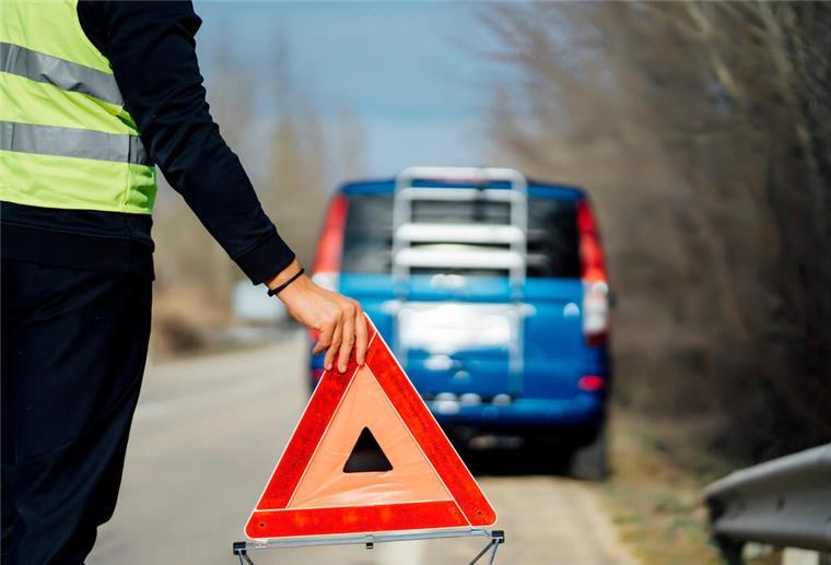 Hilfe bei einer Autopanne: Mit diesen Tipps reagiert ihr richtig Warndreieck wird bei einer Autopanne aufgestellt. Bei einer Autopanne ist es wichtig, einige Tipps zu beachten.