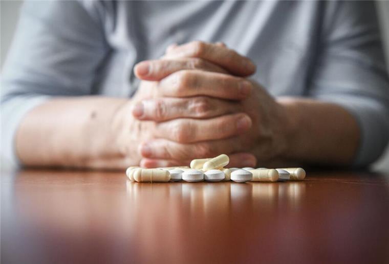 Paracetamol erhöht Risiko für Herz- und Nierenerkrankungen bei Senioren Hände auf einem Tisch mit Tabletten.