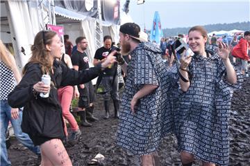 Party im Matsch: Vom Wetter lassen sich die Besucher ihre Stimmung keineswegs ve...