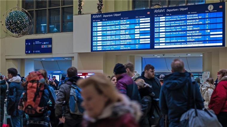 Passagiere warten am Hauptbahnhof in Hannover vor einem Infoschalter.