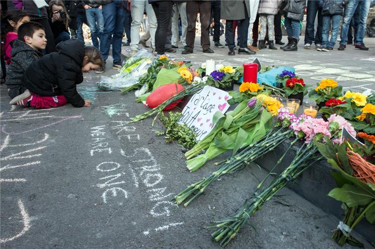 Anschläge: Polizei in Brüssel hat Fahndungsfoto rausgegeben Passanten legen am vor der Börse am Place de la Bourse in Brüssel Kerzen und Blumen nieder. Nach jetzigem Stand sind 34 Menschen getötet worden, rund 230 wurden verletzt.