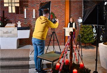 Mann und Frau in der Kirche, Mann filmt mit Kamera. Pastorin Katharina Behrens zeichnet gemeinsam mit ihrem Mann Michael in der Lunestedter Kirche Weihnachtsgottesdienste für das Internet auf.