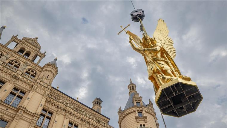 Erzengel Michael thront wieder auf dem Schweriner Schloss Per Kran wird der Erzengel Michael nach mehrmonatigen Sanierungsarbeiten zurück auf die Kuppel des Schweriner Schlosses befördert.