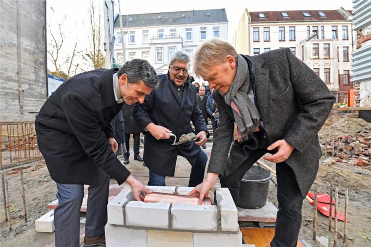 Neues Wohnheim: "Hamburger Schanze" für Bremerhaven Peter Ritzenhoff, Melf Grantz und Sieghard Lückehe (von links) mauern die Zeitkapsel bei der Grundsteinlegung ein.