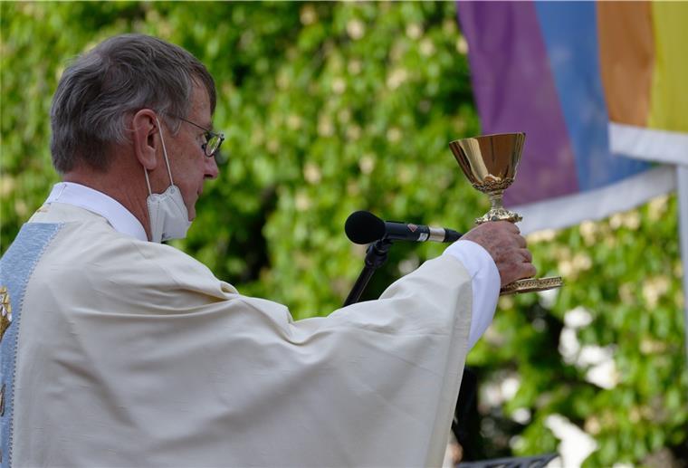 Gegen den Papst-Willen: Katholische Pfarrer segnen Homosexuelle Pfarrer Ulrich Hinzen hält bei einem Open-Air-Segnungsgottesdienst für Liebende vor der Kirche Christi Auferstehung in Köln einen Kelch. Im Hintergrund ist eine Regenbogenfahne zu sehen.