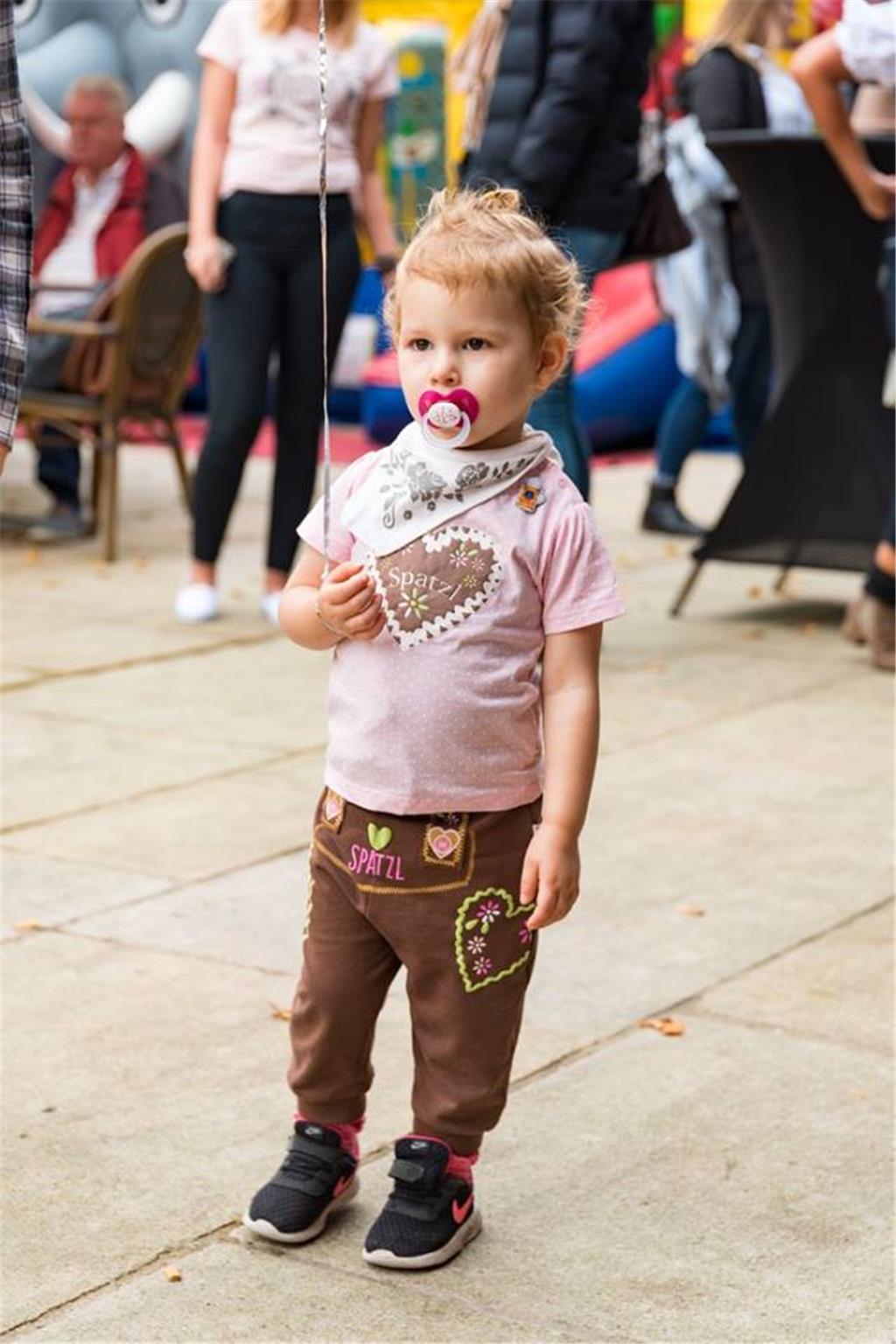 Kind mit Schnuller und in Lederhosen
