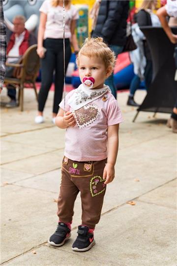 Kind mit Schnuller und in Lederhosen