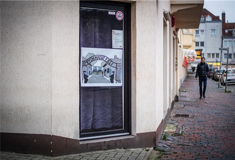 „Spaziergänge“ sorgen für zahlreiche Überstunden bei der Polizei Eine Plakat klebt auf einer Fensterscheibe.