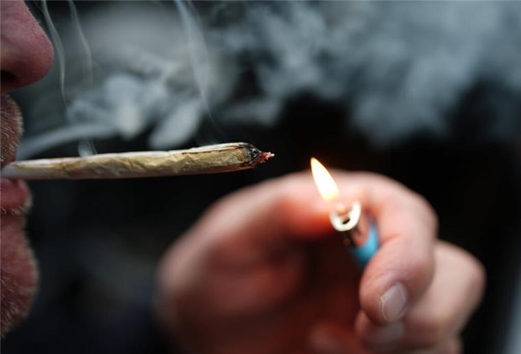 Cannabis-Legalisierung: Schwarzmarkt bleibt, Kinder nicht besser geschützt ARCHIV - 05.01.2025, Hamburg: ILLUSTRATION - Ein Mann zündet sich in einem Auto einen Joint an. (zu dpa: «Ministerin: Cannabis-Gesetz erfüllt Ziele bisher nicht») Foto: Marcus Brandt/dpa +++ dpa-Bildfunk +++