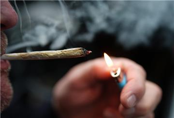 ARCHIV - 05.01.2025, Hamburg: ILLUSTRATION - Ein Mann zündet sich in einem Auto einen Joint an. (zu dpa: «Ministerin: Cannabis-Gesetz erfüllt Ziele bisher nicht») Foto: Marcus Brandt/dpa +++ dpa-Bildfunk +++