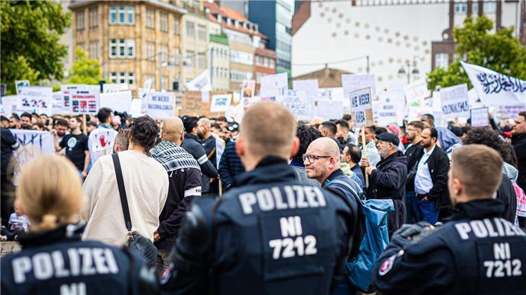Polizisten beobachten zahlreiche Demonstranten.