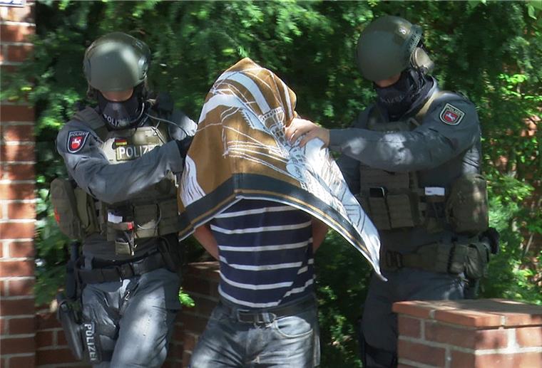 Prozess in Kiel: Mann soll Tod auf der Ostsee vorgetäuscht haben Polizisten führen den Verdächtigen nach einem Einsatz in Schwarmstedt im Mai in Handschellen ab.