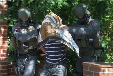 Polizisten führen den Verdächtigen nach einem Einsatz in Schwarmstedt im Mai in Handschellen ab.