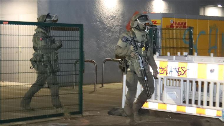 Polizisten in Spezialausrüstung verlassen ein Hochhaus in Berlin-Friedrichshain.