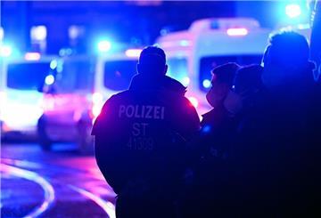 Polizisten vor Einsatzfahrzeugen