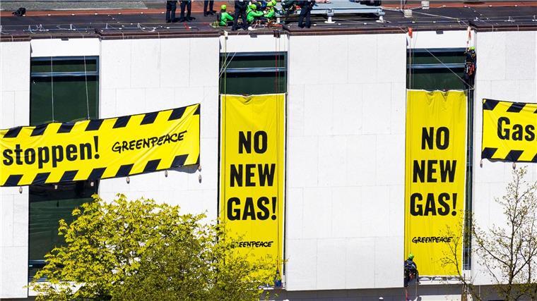Polizisten stehen auf dem Dach des niedersächsischen Landtags neben Aktivisten von Greenpeace.