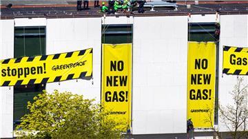 Polizisten stehen auf dem Dach des niedersächsischen Landtags neben Aktivisten von Greenpeace.