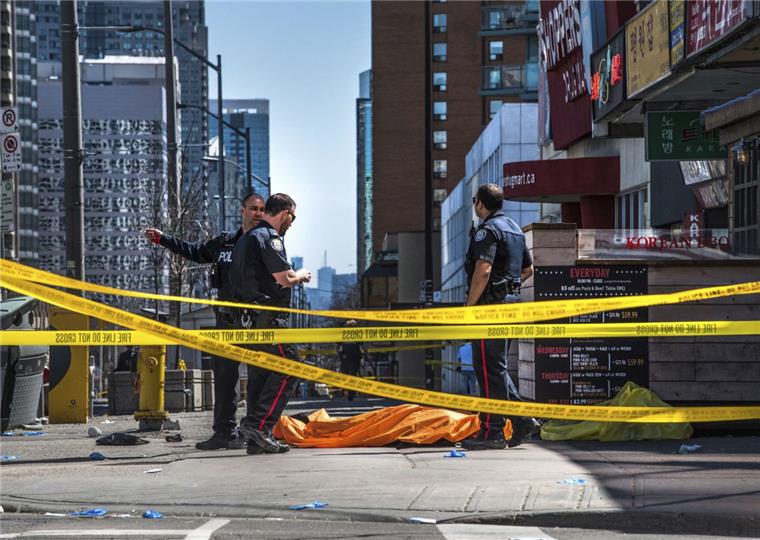 Toronto: Mann rast mit Lieferwagen über Gehweg und tötet zehn Menschen Polizisten stehen neben einer zugedeckten Leiche, nachdem ein Lieferwagen in eine Gruppe von Fußgängern fuhr und dabei mehrere Menschen erfasste.