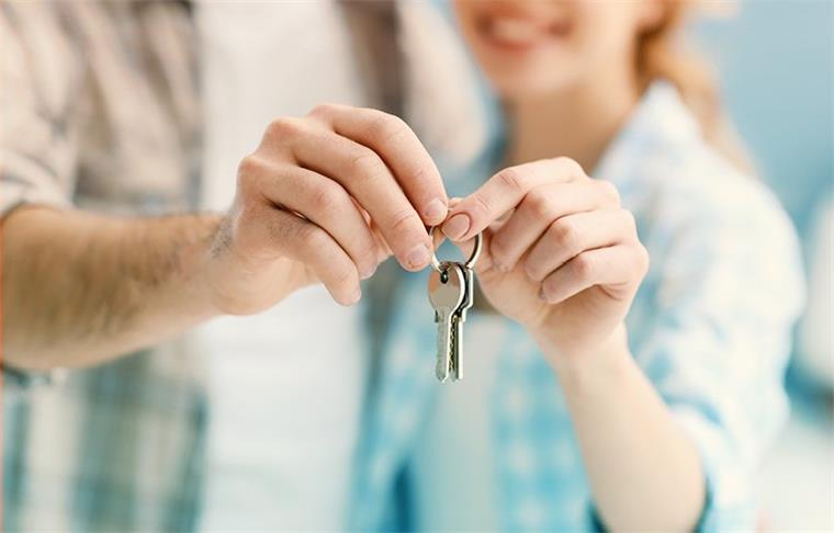 Seriöse Ansprechpartner in allen Immobilienfragen Glueckliches Paerchen haelt einen Wohnungsschluessel fest.