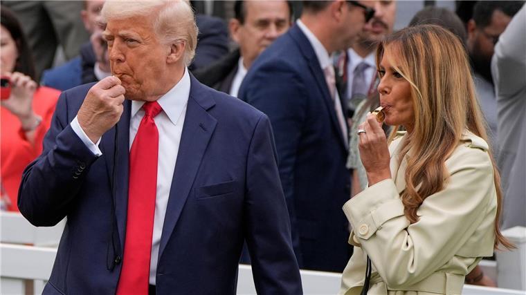 Präsident Donald Trump und Melania Trump blasen während des White House Easter Egg Roll in Trillerpfeifen.