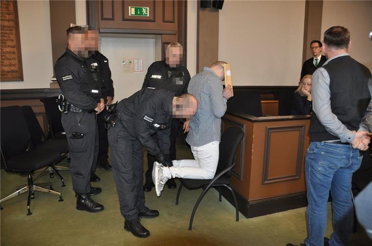 Prozessauftakt: Wachleute führen einen der Angeklagten in den Gerichtssaal.