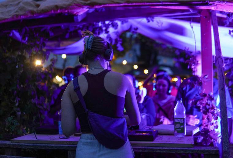 Frau am DJ-Pult von hinten