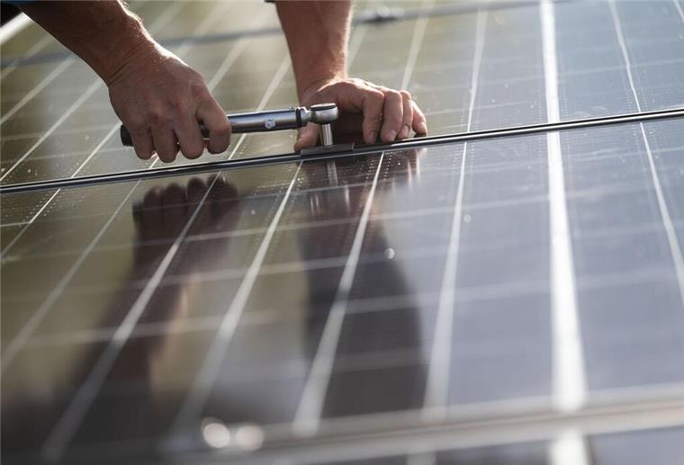 Photovoltaik auf dem Dach: Wann sich die Solaranlage wirklich lohnt Mitarbeiter einer Firma montieren Photovoltaikmodule auf dem Dach eines Wohnhauses.