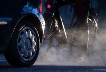 ARCHIV - 23.11.2021, Baden-Württemberg, Stuttgart: Ein Radfahrer steht neben einem Auto von Mercedes mit Dieselantrieb, dessen Abgase in der kalten Morgenluft sichtbar werden. (zu dpa: «Nur noch am Bodensee höhere Feinstaubbelastung») Foto: Marijan Murat/dpa +++ dpa-Bildfunk +++