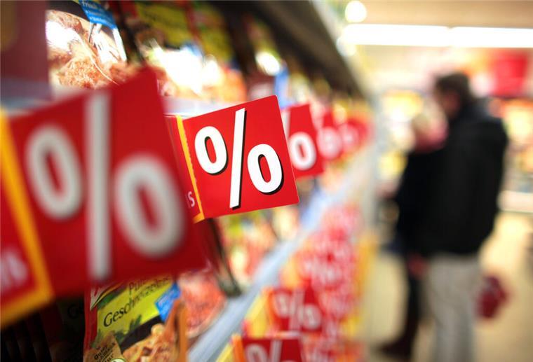 Mehr Sonderangebote verkauft – Händler und Hersteller unter Druck Prozentzeichen hängen in einem Supermarkt an Regalen. (zu dpa "Zu Ostern locken die Sonderangebote") +++ dpa-Bildfunk +++