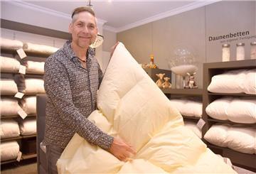 Ralf Neemann erlärt ein Daunenbett.
