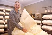 Ralf Neemann erlärt ein Daunenbett.
