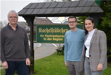 Ralph Krümpelmann (links) übergibt das „Kachelstübchen“ an Tatjana Henke und Daniel Scheffel.