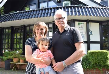 Eine Familie steht vor einem Restaurant.