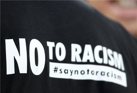  "No to Racism" ("Nein zu Rassismus") steht auf dem Aufwärmtrikot eines Sportlers.