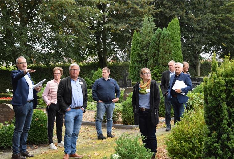 Ratsherr Olaf Wendelken (links) erläutert Mitgliedern der Bewertungskommission des Landkreises die nun laufende Umgestaltung des Friedhofes in Rhade.