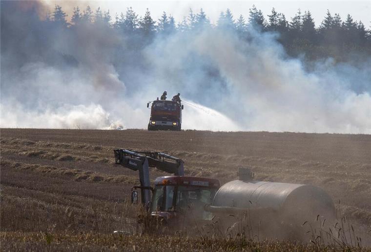 Rauchschwaden ziehen über die Feldmark im Juli 2019 : Die Feuerwehren versuchen, einen benachbarten Campingplatz bei Midlum zu schützen.  