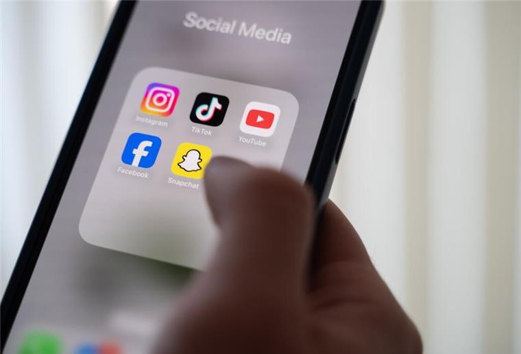 Teilen oder liken – und dann vor Gericht? Wann du für Likes und Shares haftest ARCHIV - 24.10.2024, Niedersachsen, Hannover: ILLUSTRATION - Eine Frau hält ein Smartphone, auf dessen Display verschiedene Social Media Apps angezeigt werden. (zu dpa: «Kultusministerium lehnt Verbot sozialer Medien unter 16 ab») Foto: Alicia Windzio/dpa +++ dpa-Bildfunk +++