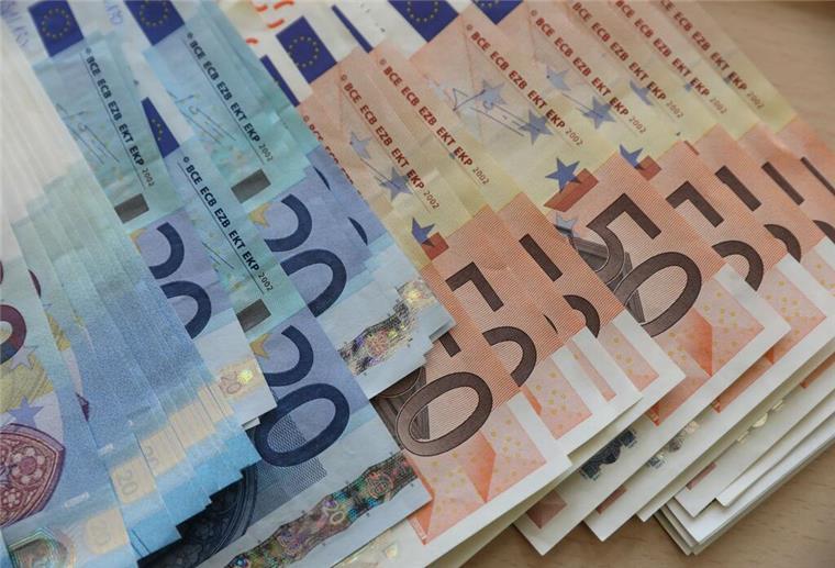 Spitzensteuersatz gilt für Millionen Deutsche: Ab diesem Einkommen wird er fällig Euro-Geldscheine liegen aufgereiht auf einem Tisch.