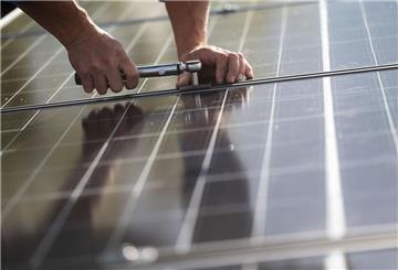 Mitarbeiter einer Firma montieren Photovoltaikmodule
