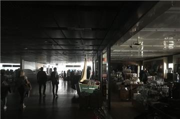 Reisende gehen während eines Stromausfalls durch den unbeleuchteten Hamburger Flughafen.

