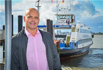 Ein Mann vor einem Schiff.