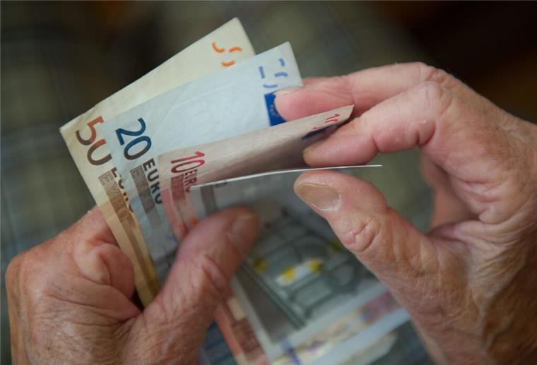 Eine Rentnerin zählt Geld.