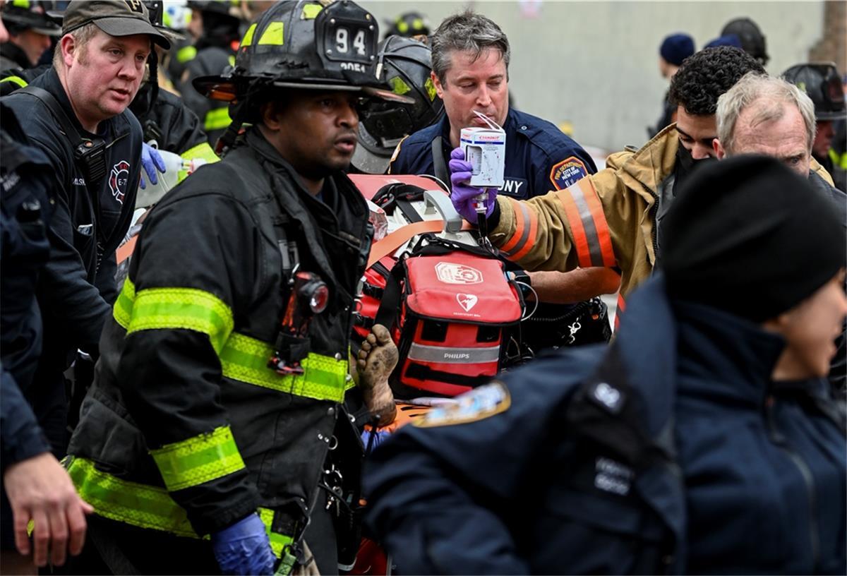 19 Tote bei Wohnhausbrand in New York Rettungskräfte bringen ein Brandopfer während eines Hochhausbrandes in der East 181 Street im New Yorker Stadtbezirk Bronx in einen Krankenwagen.