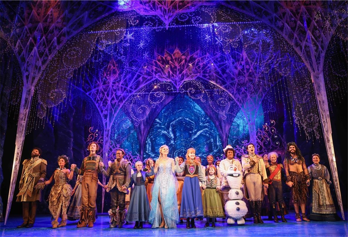 Sabrina Weckerlin (als Eiskönigin Elsa, Mitte, links), Celena Pieper (als Anna, die Schwester der Eiskönigin, Mitte, rechts), und weitere Musicaldarsteller stehen nach der Deutschlandpremiere des Disney-Musicals "Die Eiskönigin" auf der Bühne im Stage Theater an der Elbe.